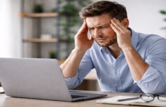 Ein Mann sitzt vor seinem PC, mit dem er offensichtlich grosse Probleme hat